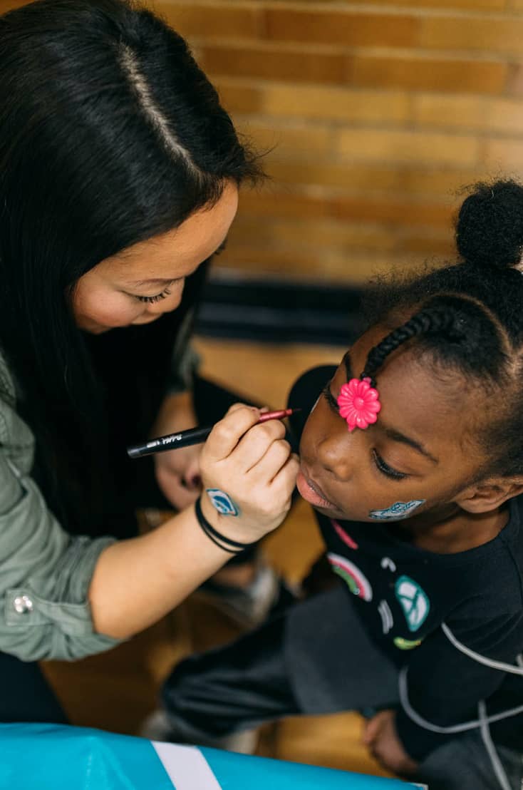 Our design director Amy doing face paint for an after-school program participant.